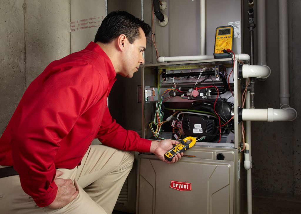 HVAC technician repairing an indoor furnace in Colorado Springs