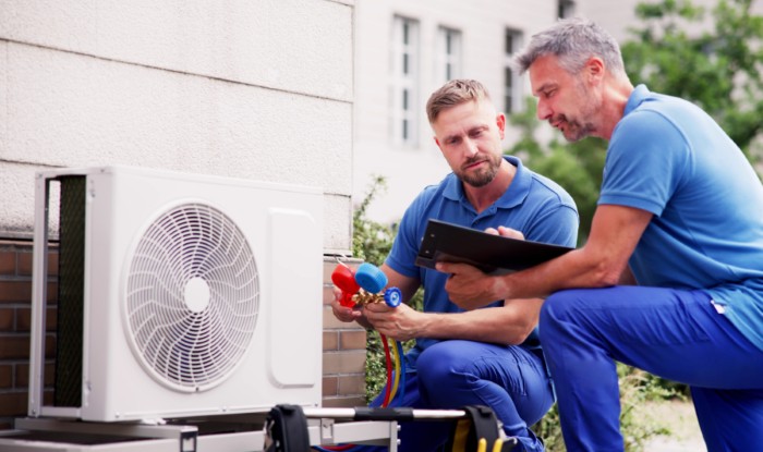 HVAC technicians installing an outdoor air conditioning unit in Colorado Springs