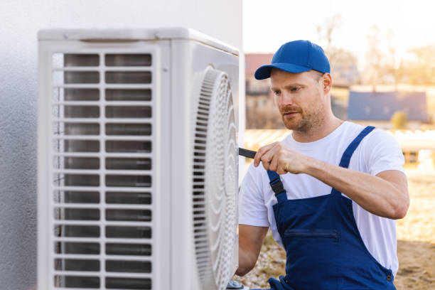 HVAC technician servicing an outdoor air conditioning unit in Colorado Springs