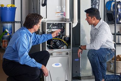 65df8c11f3e4c468cbd351a5_furnace repair vs replacement – Copy HVAC technician explaining furnace repair and maintenance to a homeowner in Colorado Springs, CO