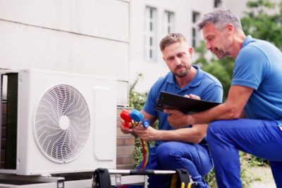 ac-installation-in-claremont-ca HVAC technicians reviewing an outdoor air conditioning unit in Colorado Springs, CO