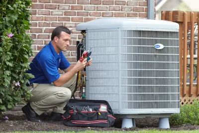 design-air-heating-and-air-conditioning-decatur-il-05 – Copy HVAC technician inspecting an outdoor air conditioning unit in Colorado Springs, CO
