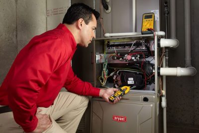 furnace repair Heating and air conditioning technician servicing an indoor furnace in Colorado Springs, CO